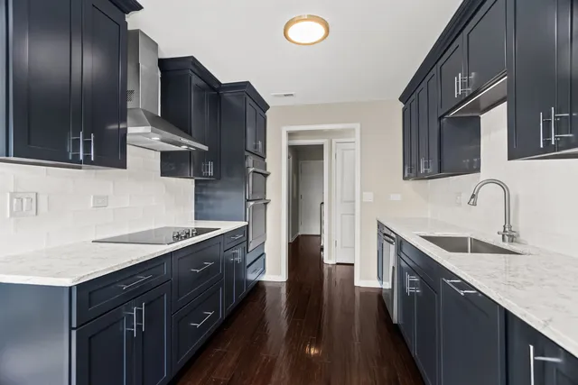 a kitchen with granite countertop stainless steel appliances a sink stove top oven and refrigerator