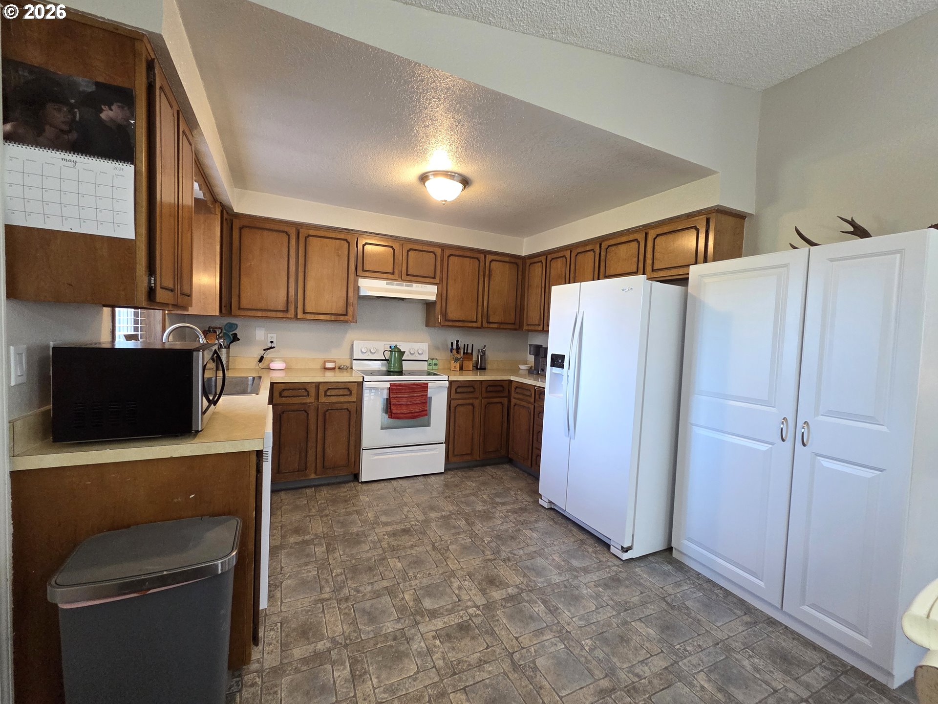 740 North 11th Street Elgin, OR 97827 - Photo 5 of 20 a kitchen with a refrigerator a stove top oven a sink and cabinets