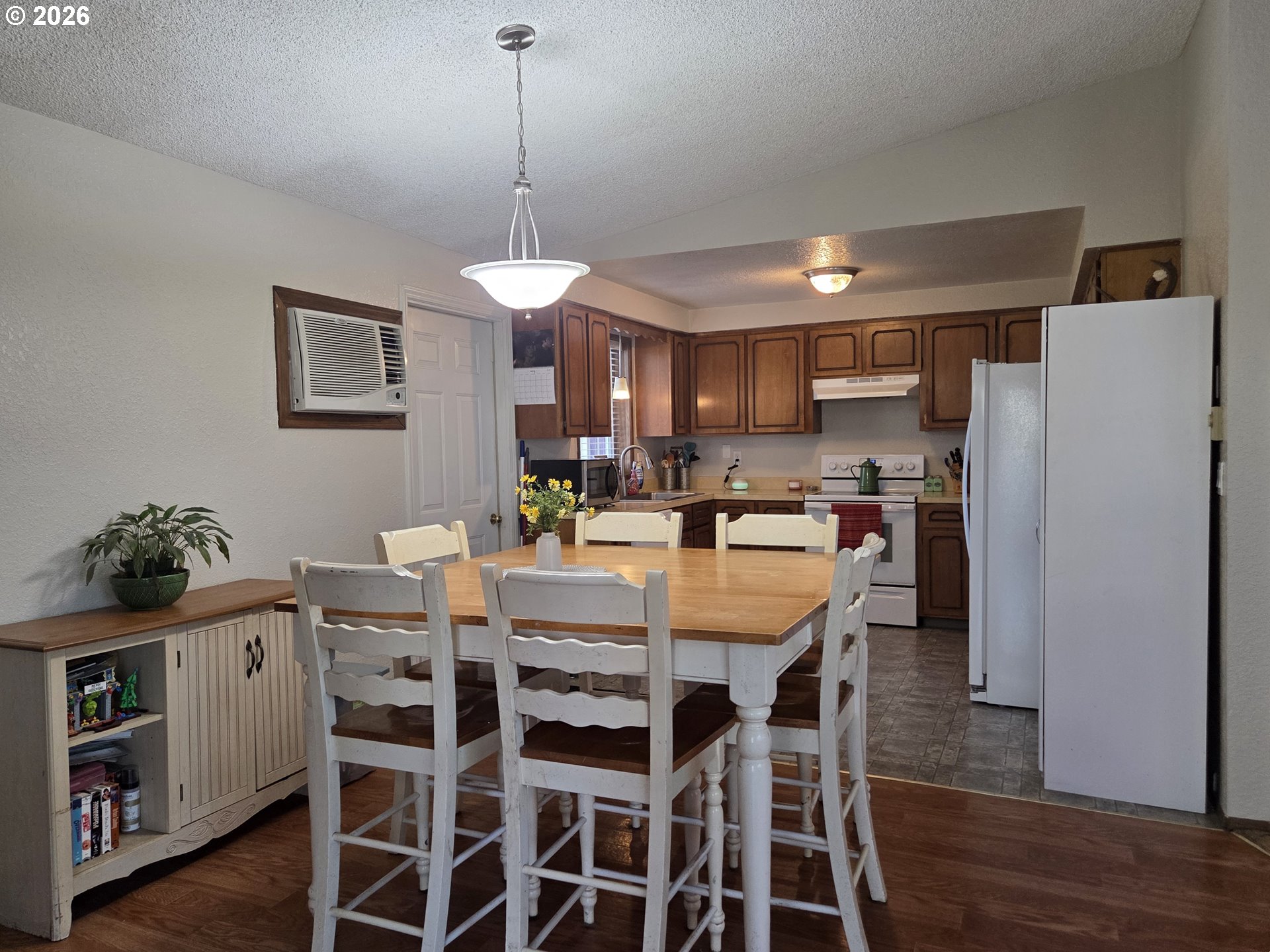 740 North 11th Street Elgin, OR 97827 - Photo 6 of 20 a kitchen with stainless steel appliances a dining table chairs and white cabinets