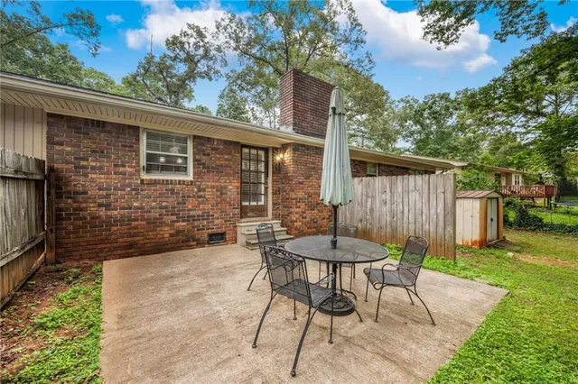 a view of a patio with table and chairs with wooden fence and floor
