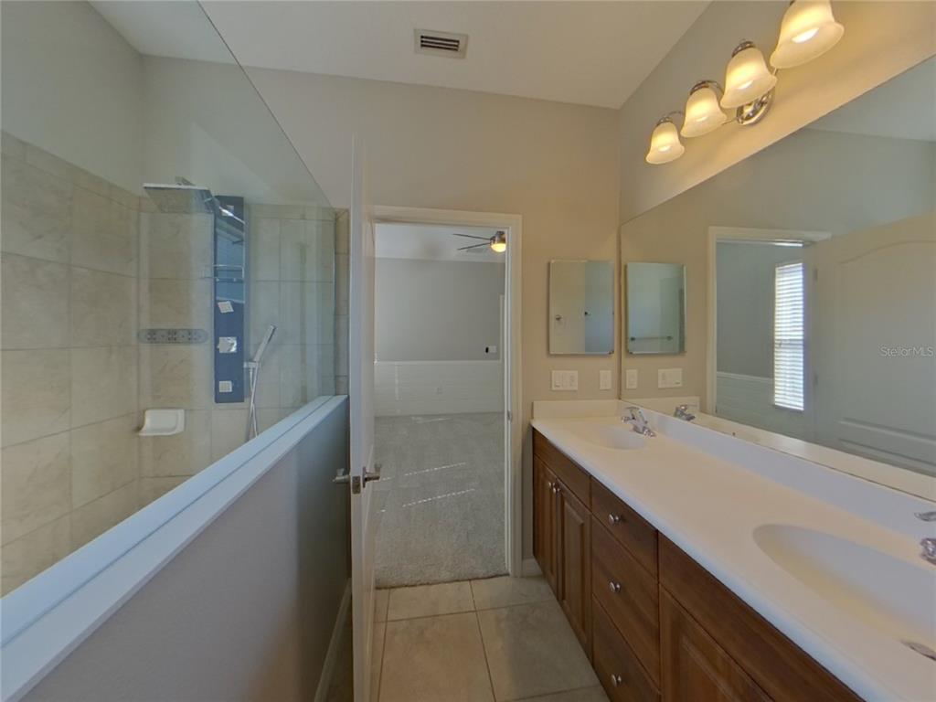 Undisclosed Address Parrish, FL 34219 - Photo 9 of 16 a spacious bathroom with a double vanity sink mirror and shower