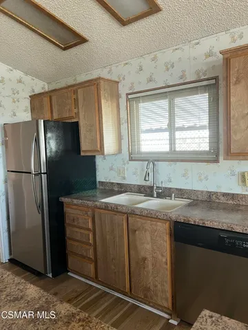 a kitchen with stainless steel appliances granite countertop a refrigerator and a sink