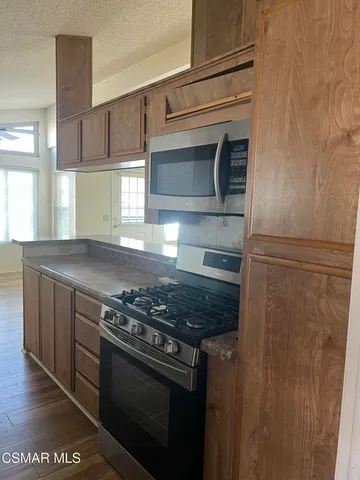 a kitchen with stainless steel appliances granite countertop a stove and a microwave