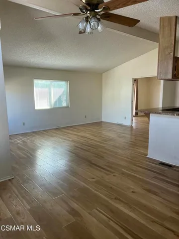 a view of a livingroom with a ceiling fan and wooden floor