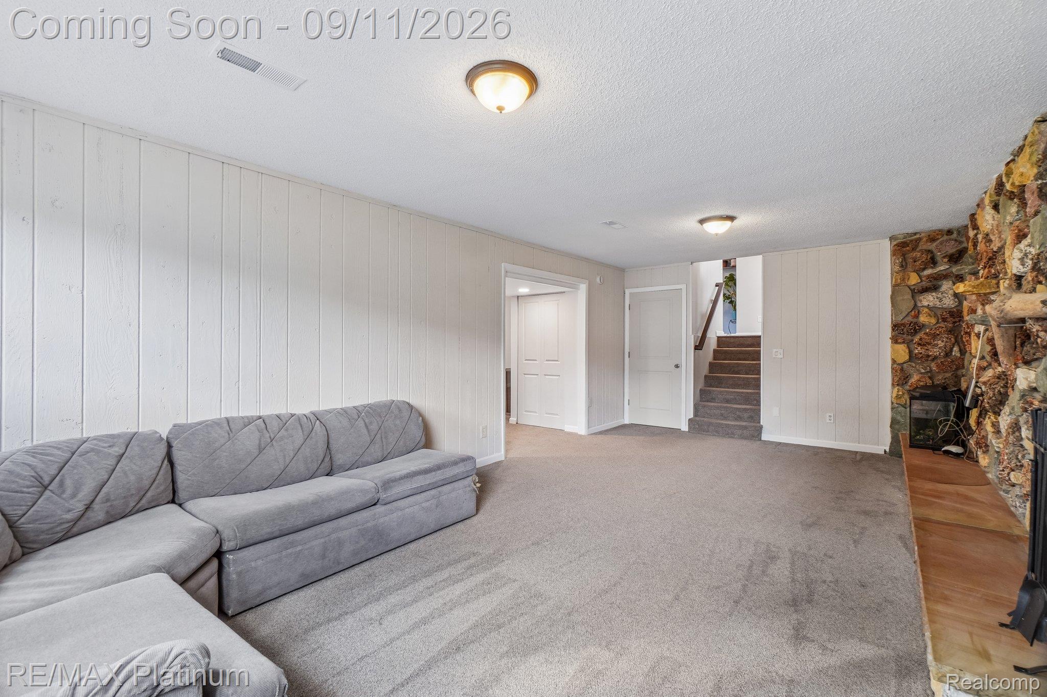 12126 Linden Road Linden, MI 48451 - Photo 22 of 38 Carpeted living space featuring a stone-clad fireplace and wood mantel