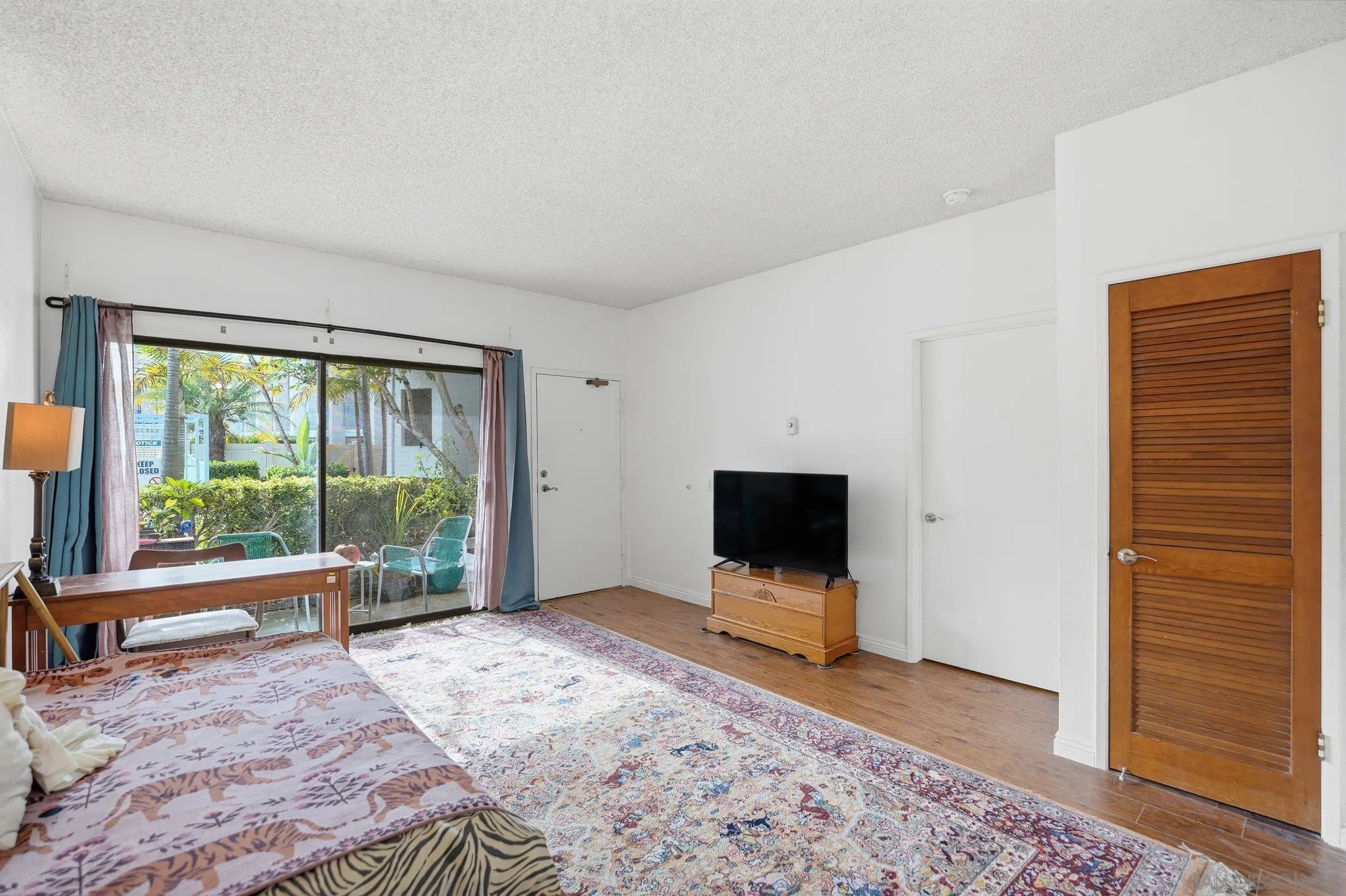 8310 Regents Road, Unit 1E San Diego, CA 92122 - Photo 3 of 28 a view of a livingroom with wooden floor and a flat screen tv