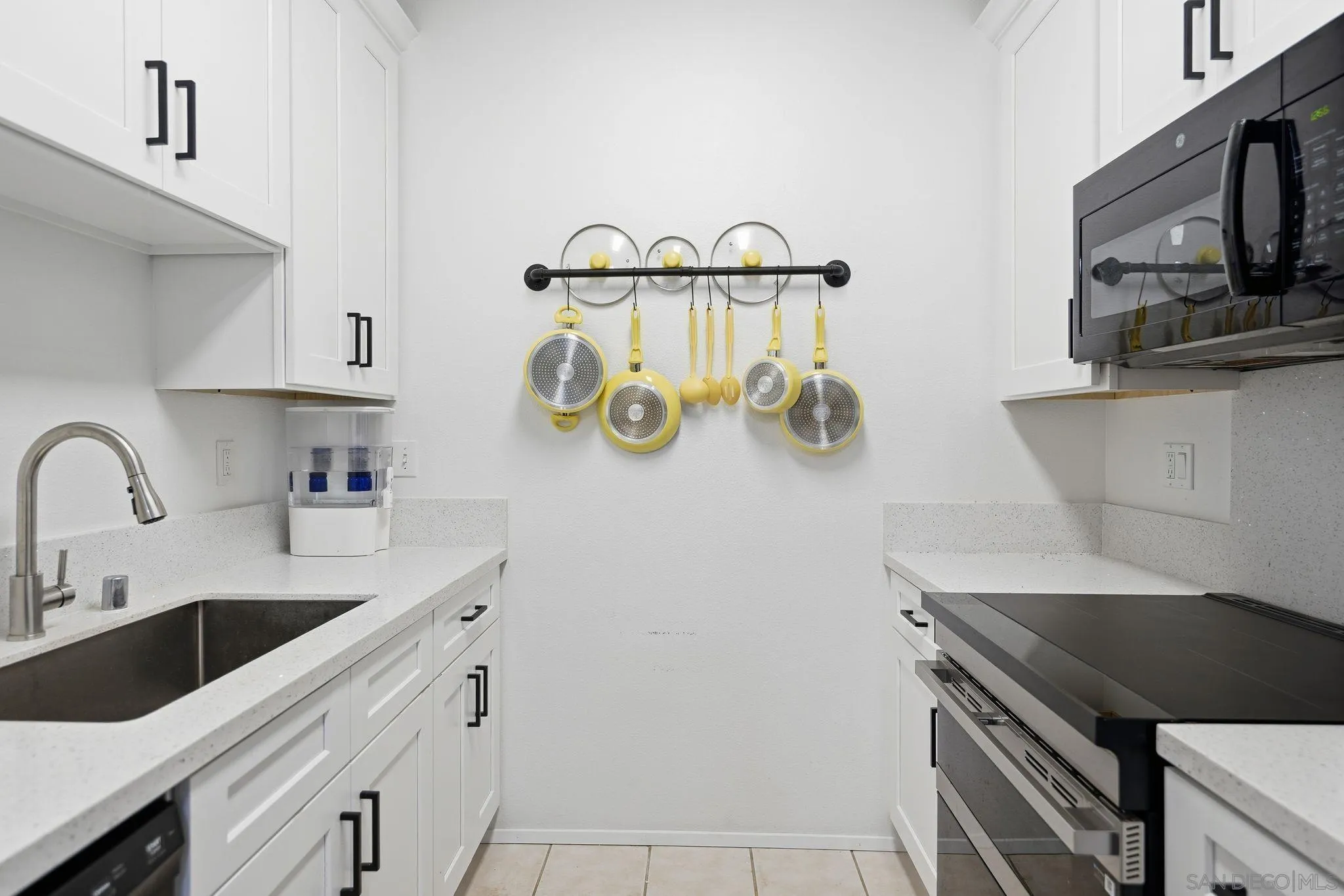 8310 Regents Road, Unit 1E San Diego, CA 92122 - Photo 10 of 28 a kitchen with stainless steel appliances a sink a stove and a microwave