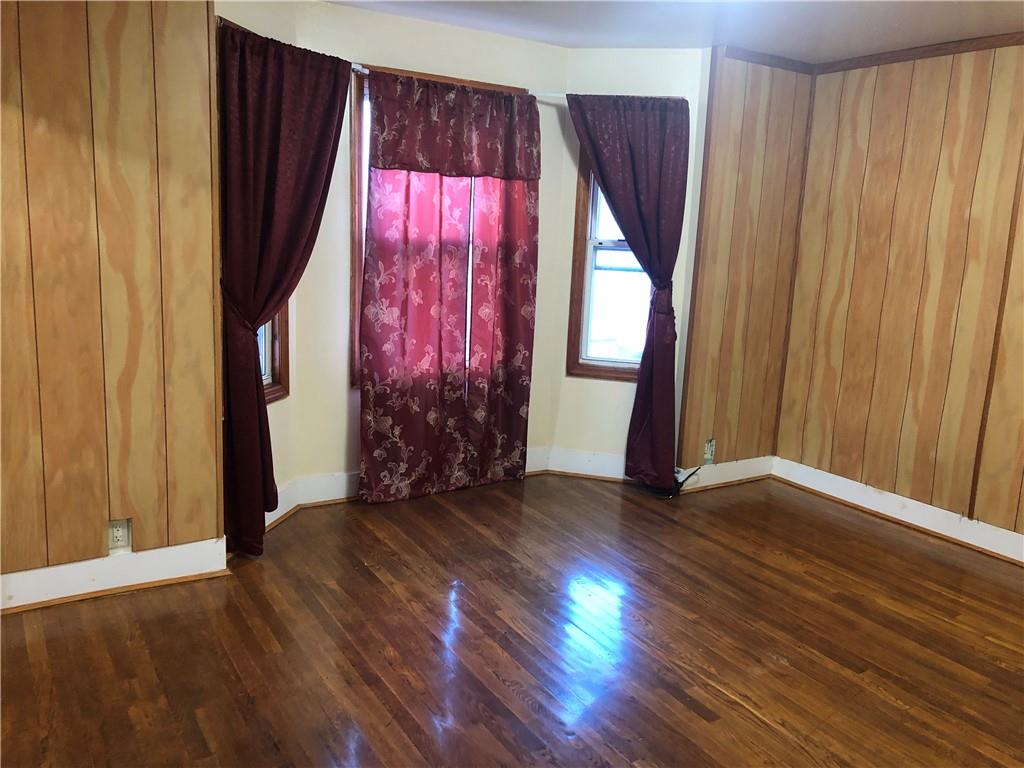 420 Stratford Road Brooklyn, NY 11218 - Photo 11 of 20 an empty room with wooden floor and windows