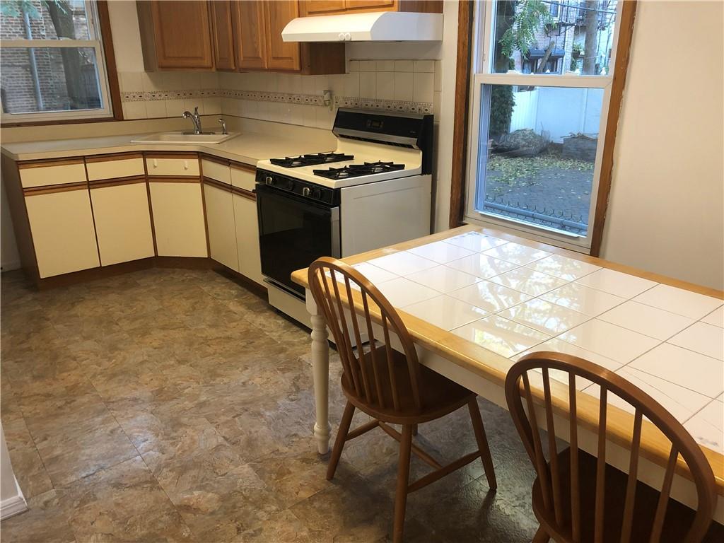 420 Stratford Road Brooklyn, NY 11218 - Photo 16 of 20 a kitchen with a table chairs and a stove