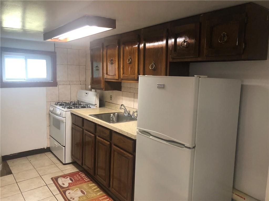 420 Stratford Road Brooklyn, NY 11218 - Photo 17 of 20 a kitchen with a refrigerator sink and cabinets