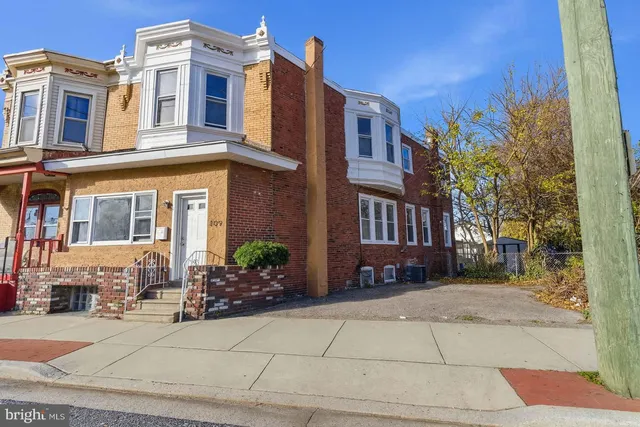 front view of a brick house with a small yard