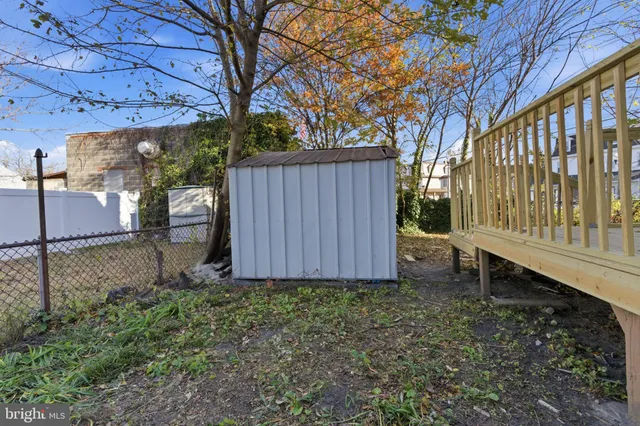 a view of a backyard with barn plants and large tree