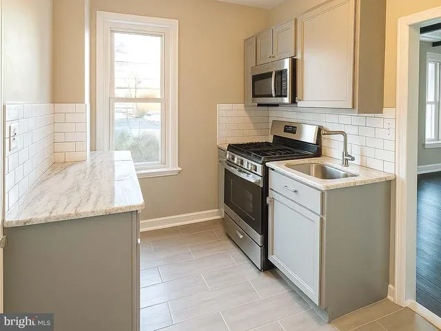 a kitchen with granite countertop a stove and a sink