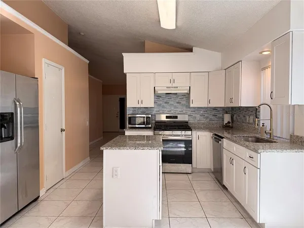 a kitchen with stainless steel appliances a sink stove refrigerator and cabinets