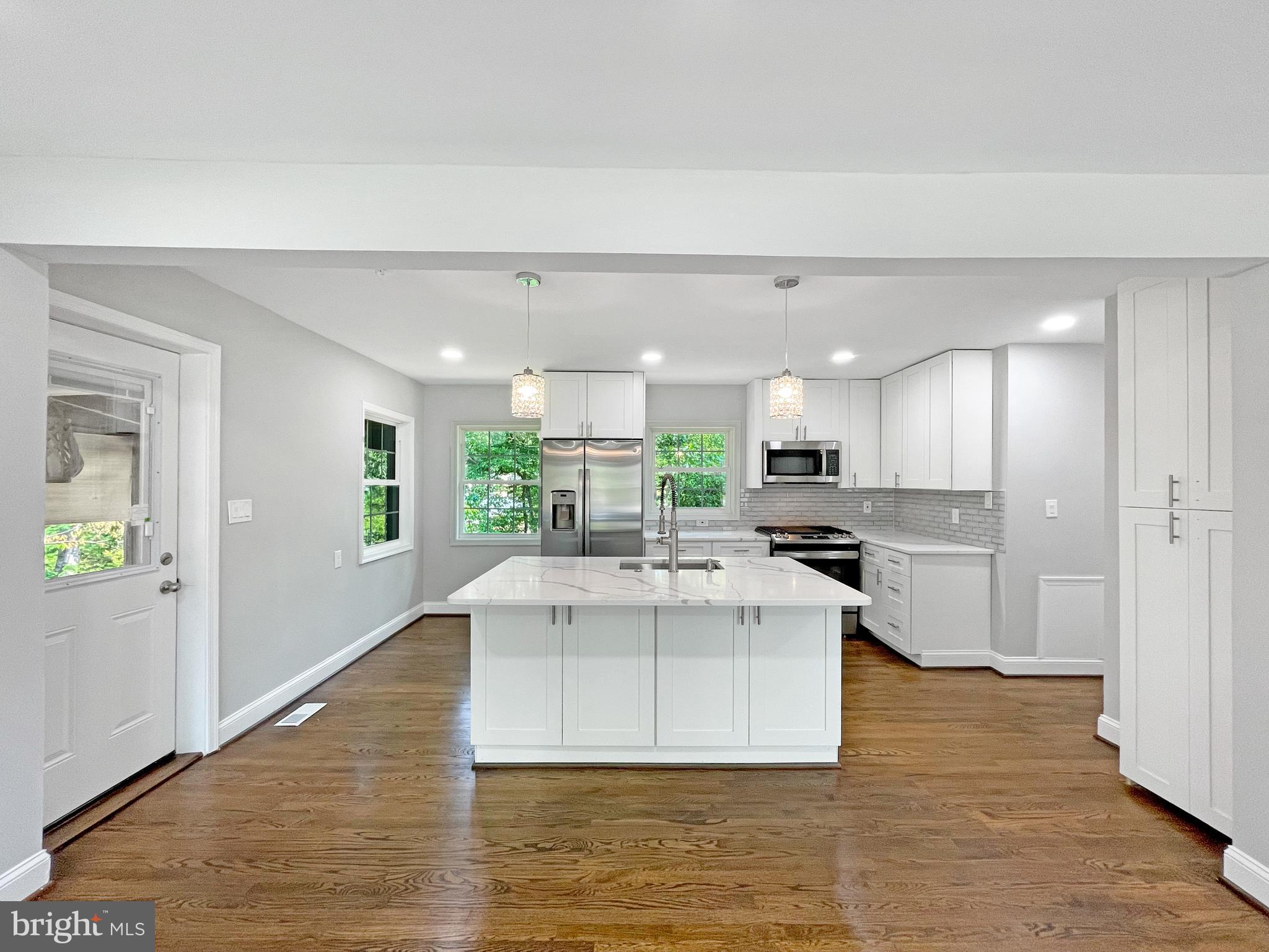 a view of kitchen with kitchen island a refrigerator a stove a sink dishwasher with a dining table and chairs
