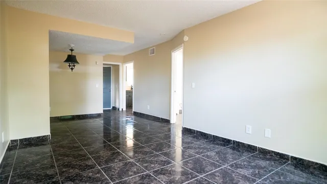 an empty room with wooden floor and a bathroom