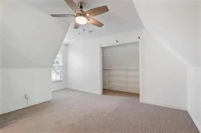 an empty room with closet and windows