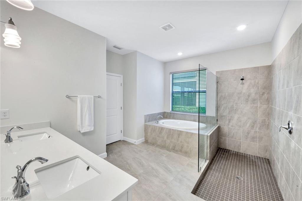 18298 Ridgeline Drive Estero, FL 33928 - Photo 20 of 49 Full bath with double vanity, a walk in shower, a garden tub, light tile patterned flooring, and recessed lighting