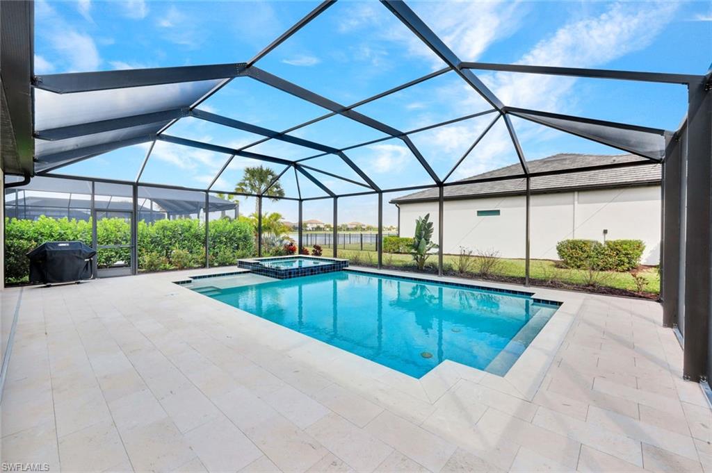18298 Ridgeline Drive Estero, FL 33928 - Photo 2 of 49 Combined pool / hot tub with a sunroom, a patio area, a lanai, and a grill