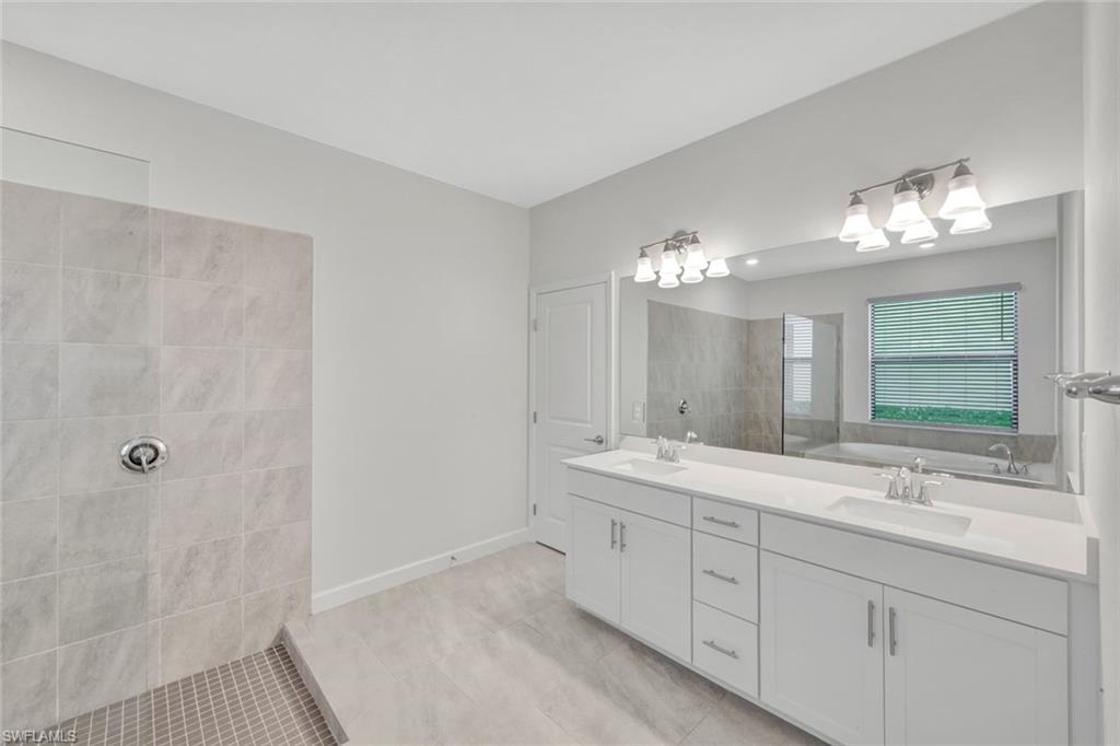 18298 Ridgeline Drive Estero, FL 33928 - Photo 21 of 49 Full bathroom with double vanity, walk in shower, and light tile patterned floors