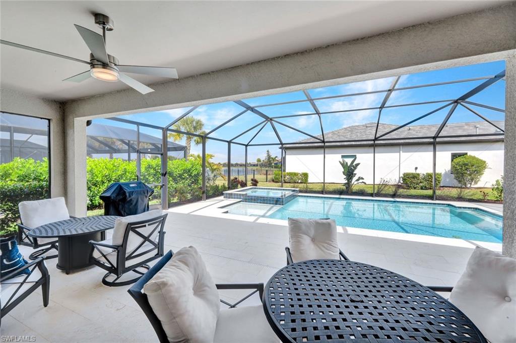 18298 Ridgeline Drive Estero, FL 33928 - Photo 28 of 49 Combined pool / hot tub featuring a patio, a sunroom, a lanai, outdoor dining area, and a grill