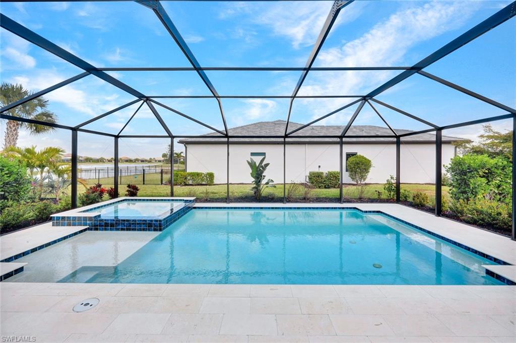 18298 Ridgeline Drive Estero, FL 33928 - Photo 29 of 49 Combined pool / hot tub with a sunroom, a patio, a lanai, and a yard