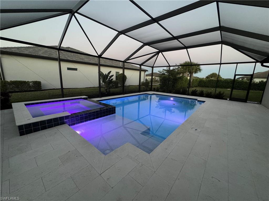 18298 Ridgeline Drive Estero, FL 33928 - Photo 32 of 49 Integrated pool / hot tub featuring a sunroom, a lanai, and a patio area