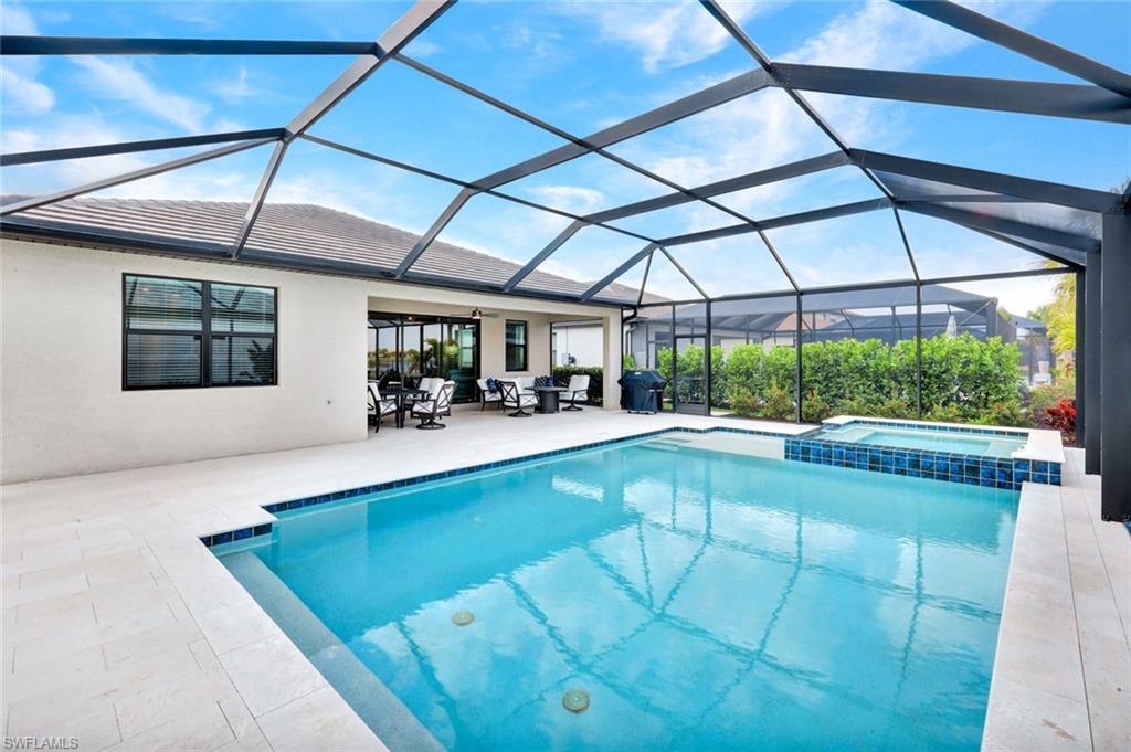 18298 Ridgeline Drive Estero, FL 33928 - Photo 33 of 49 Relaxing pool / spa with a sunroom, glass enclosure, and a patio