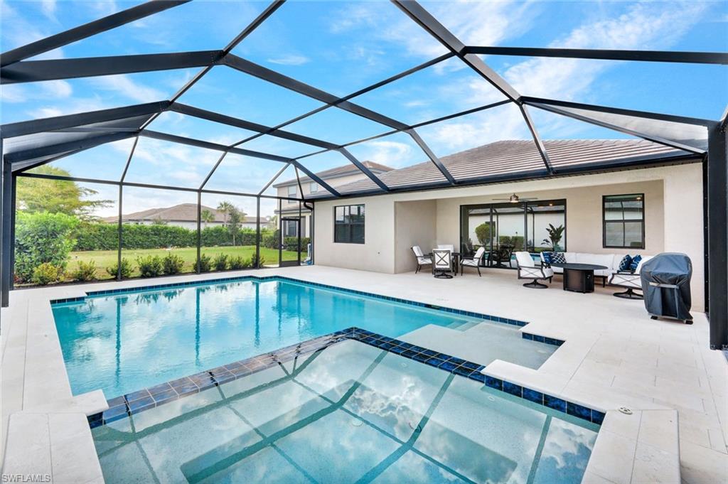 18298 Ridgeline Drive Estero, FL 33928 - Photo 35 of 49 Relaxing pool / spa with outdoor lounge area, a sunroom, and a lanai