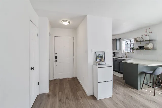 a kitchen with stainless steel appliances a refrigerator a sink dishwasher and a stove with wooden floor