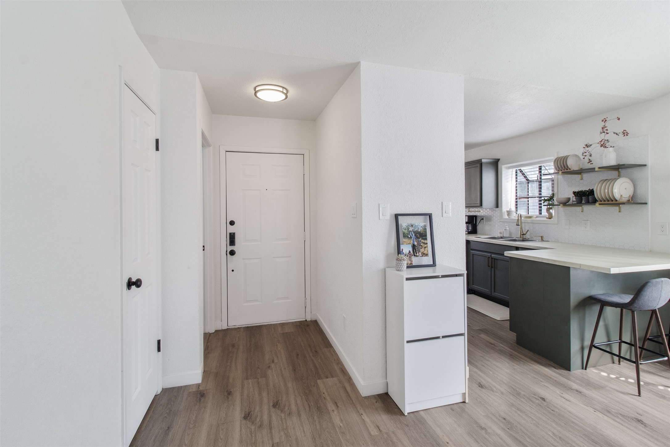 3908 Sierra Court Bryan, TX 77802 - Photo 11 of 27 a kitchen with stainless steel appliances a refrigerator a sink dishwasher and a stove with wooden floor