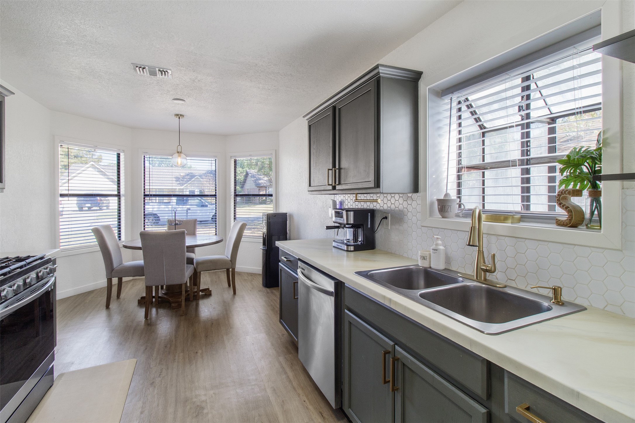 3908 Sierra Court Bryan, TX 77802 - Photo 3 of 27 a kitchen that has a sink a counter space dining table and stainless steel appliances