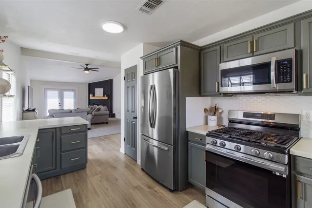a kitchen with granite countertop a refrigerator stove and microwave