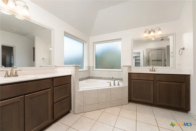a spacious bathroom with a tub sink and mirror