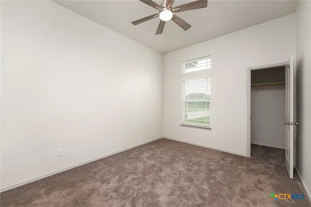 an empty room with a window and a fan