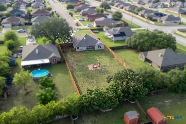 an aerial view of a house with swimming pool a yard and a patio