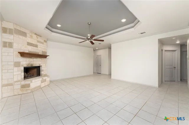 an empty room with a fireplace and fan