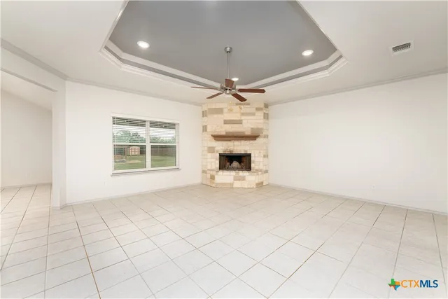 an empty room with windows and ceiling fan