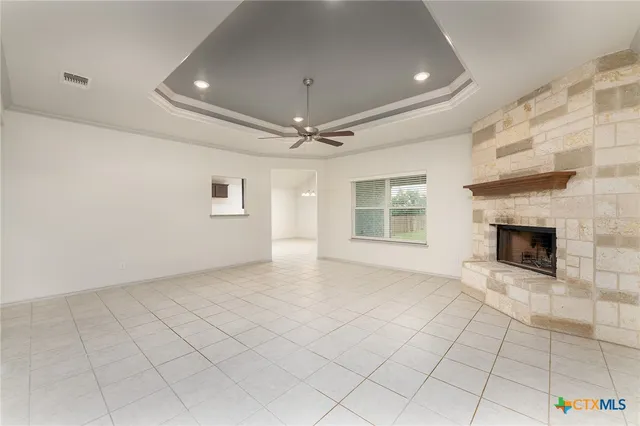 a view of an empty room with a fireplace and a window