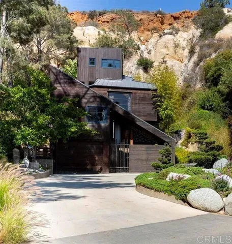 a view of house with a yard and potted plants