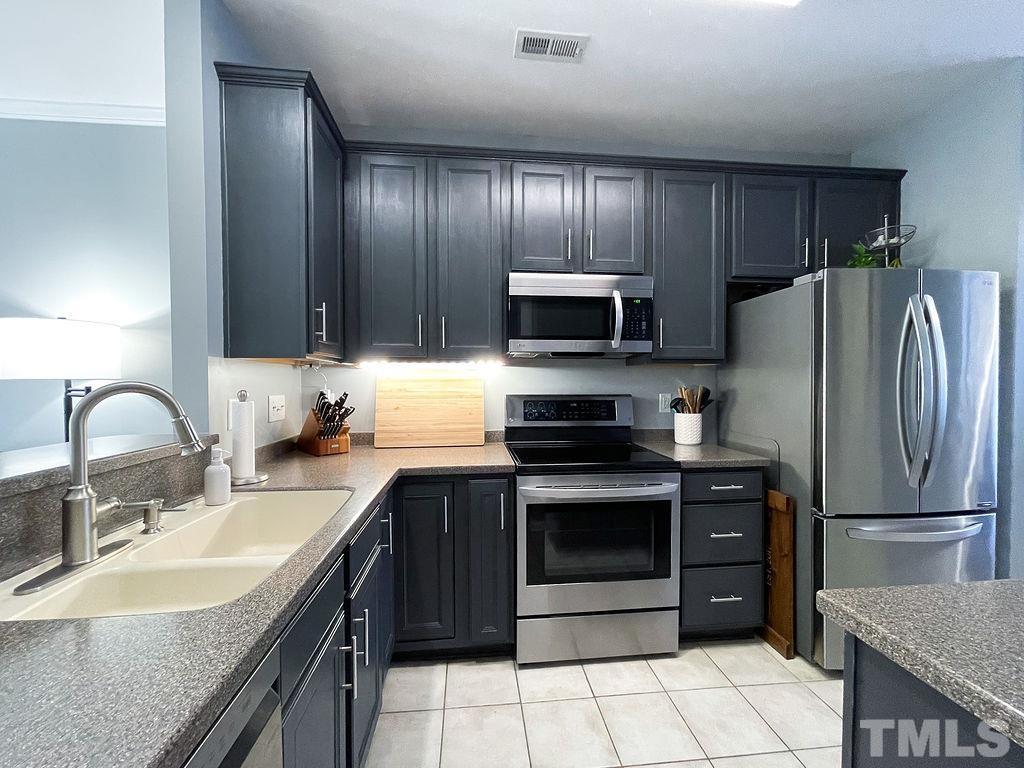 7853 Silverthread Lane Raleigh, NC 27617 - Photo 6 of 15 a kitchen with a sink stainless steel appliances and cabinets