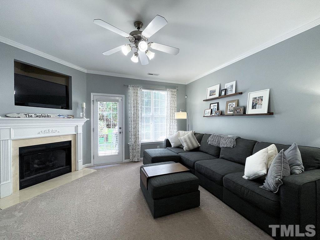 7853 Silverthread Lane Raleigh, NC 27617 - Photo 7 of 15 a living room with furniture a flat screen tv and a fireplace