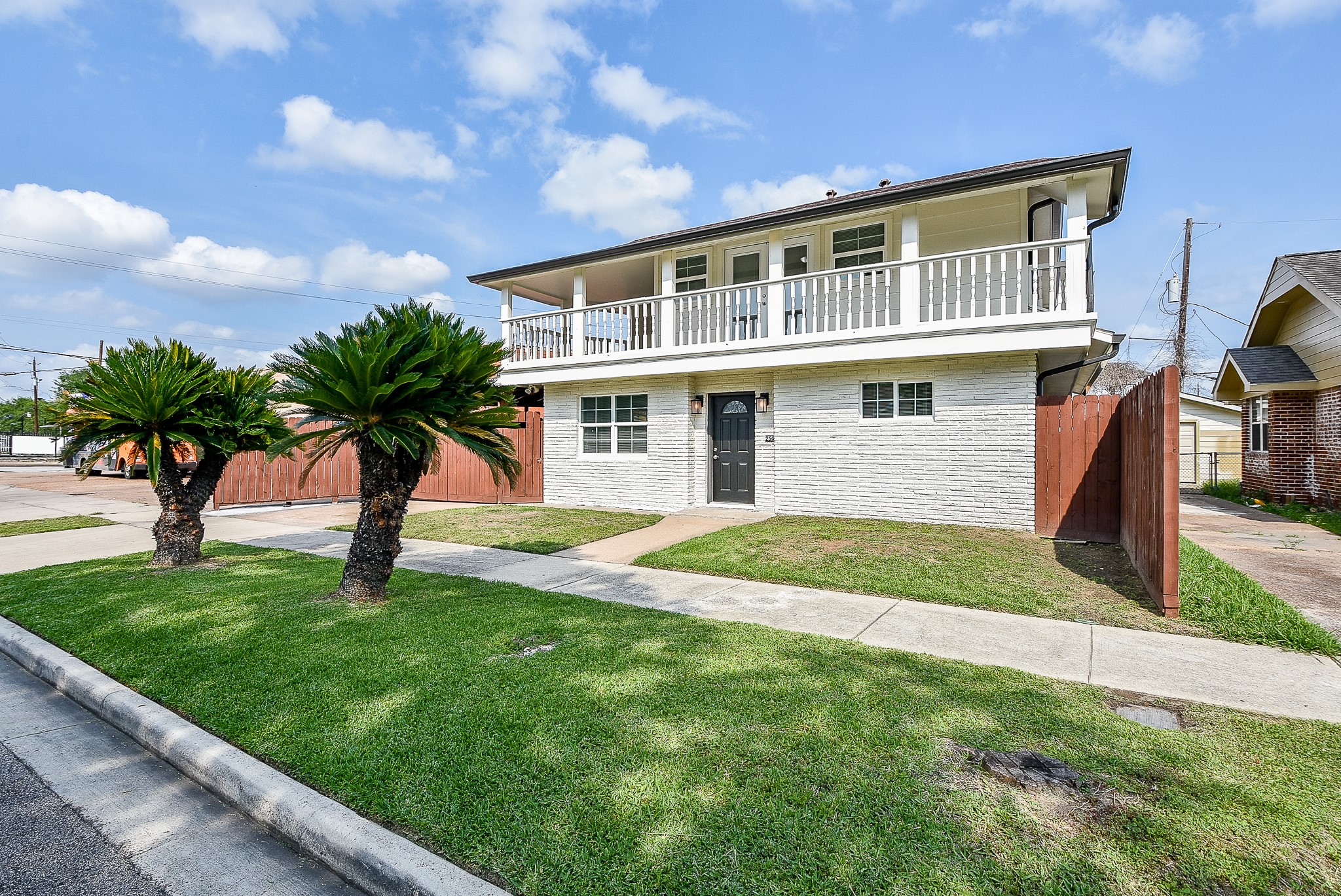 a front view of a house with a yard and potted plants