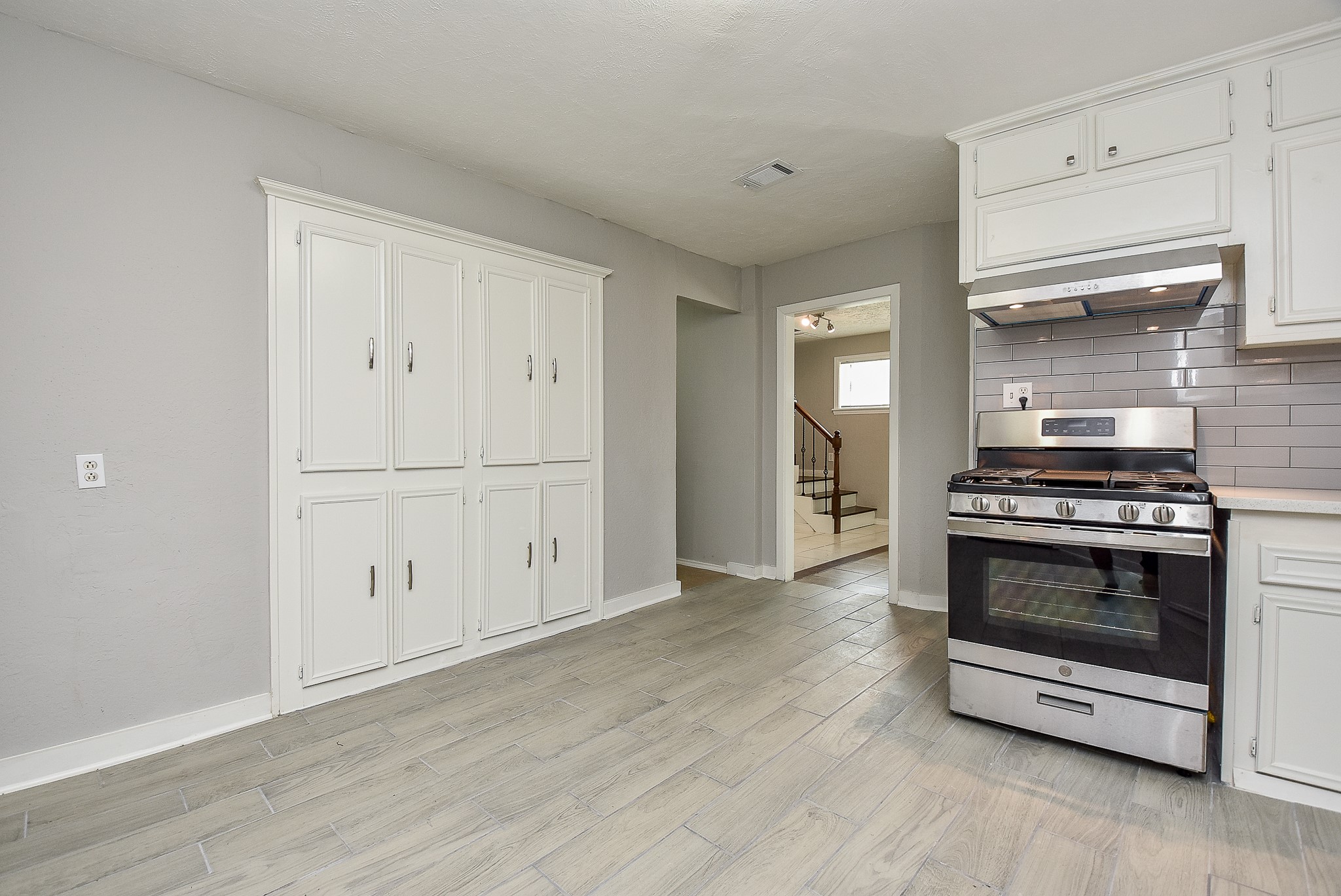 2509 Oakcliff Street Houston, TX 77023 - Photo 15 of 31 a view of kitchen and empty room with wooden floor