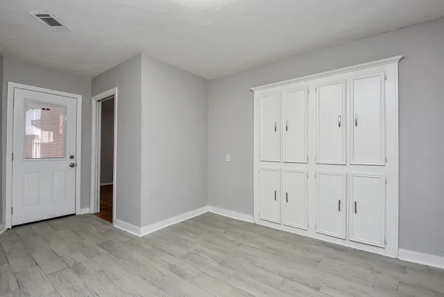a view of an empty room with wooden floor