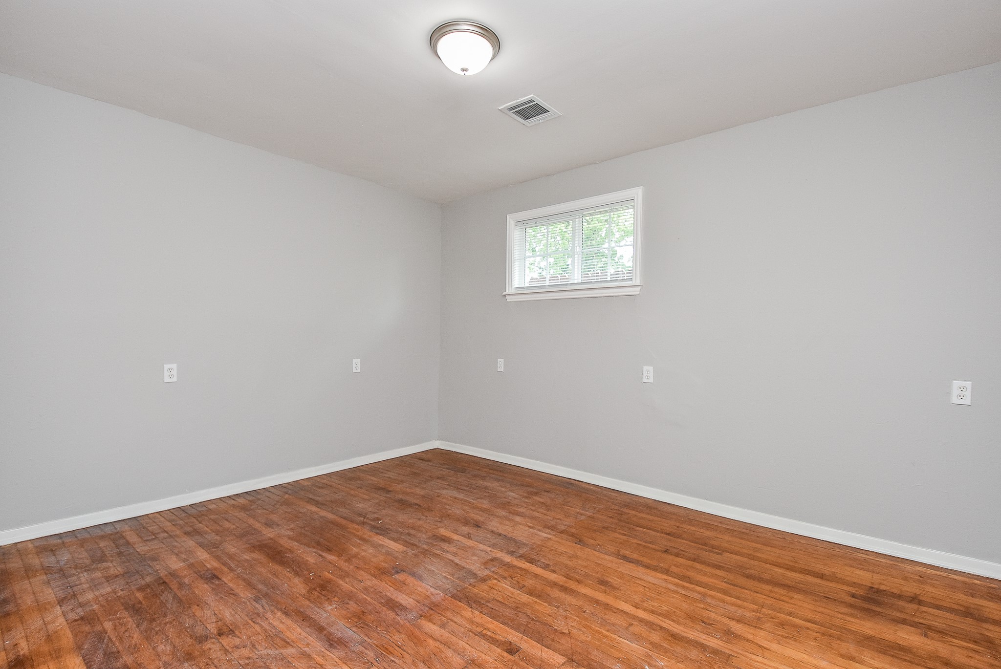 2509 Oakcliff Street Houston, TX 77023 - Photo 17 of 31 an empty room with wooden floor and windows