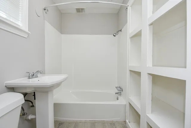 a bathroom with a sink a toilet and shower