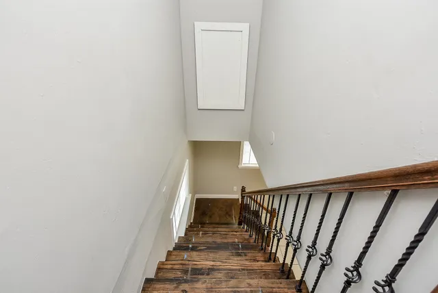 a view of a hallway with wooden floor and staircase