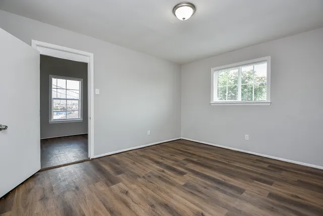 wooden floor in an empty room with a window