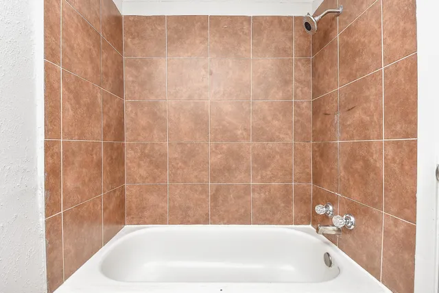 a bathroom with a white bath tub and a shower